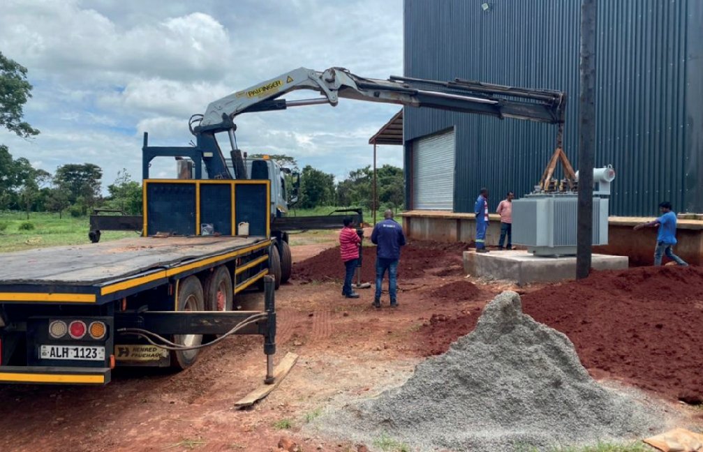 Crane truck installing an electrical transformer on site