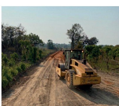 Road grader compacting a gravel road during road construction in Zambia